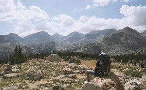 Man relaxing on a boulder looking out over a beautiful valley